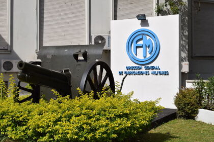 Cartel de la Dirección General de Fabricaciones Militares con un cañón de artillería histórico en primer plano
