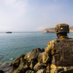 Soldado español de vigilancia frente a la barrera flotante desplegada en la frontera marítima de Ceuta
