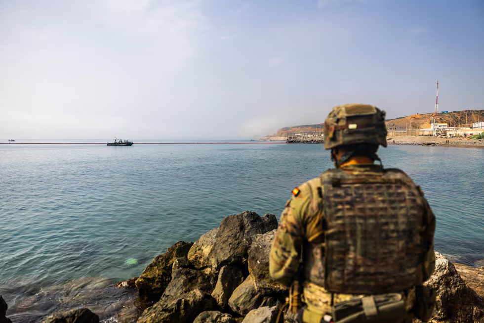 Soldado español de vigilancia frente a la barrera flotante desplegada en la frontera marítima de Ceuta