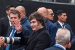 Javier Milei saluda con la mano rodeado de custodia y fotógrafos en un acto público