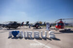 Helicópteros de Airbus en exhibición estática en FIDAE junto al letrero corporativo de la firma europea