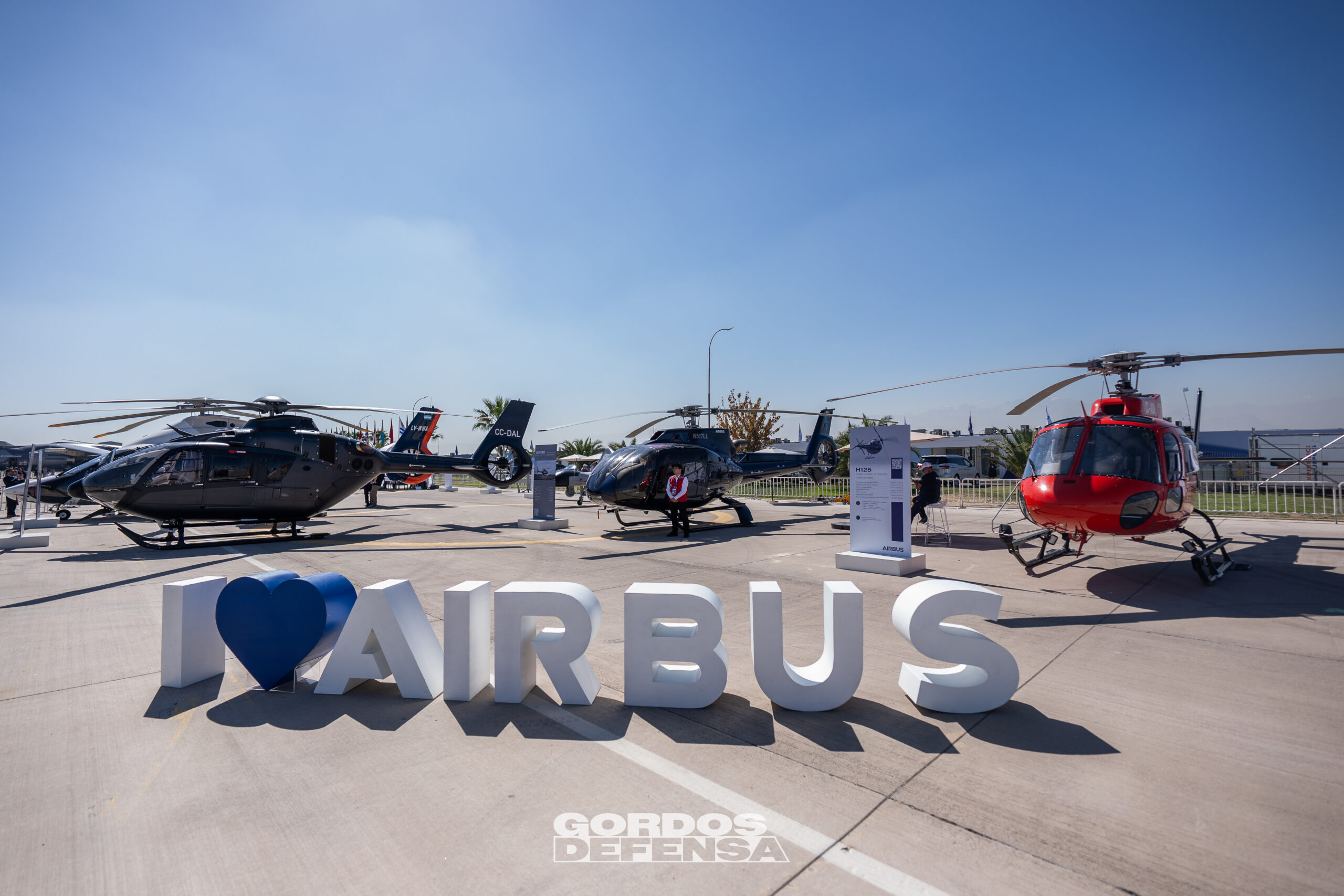Helicópteros de Airbus en exhibición estática en FIDAE junto al letrero corporativo de la firma europea
