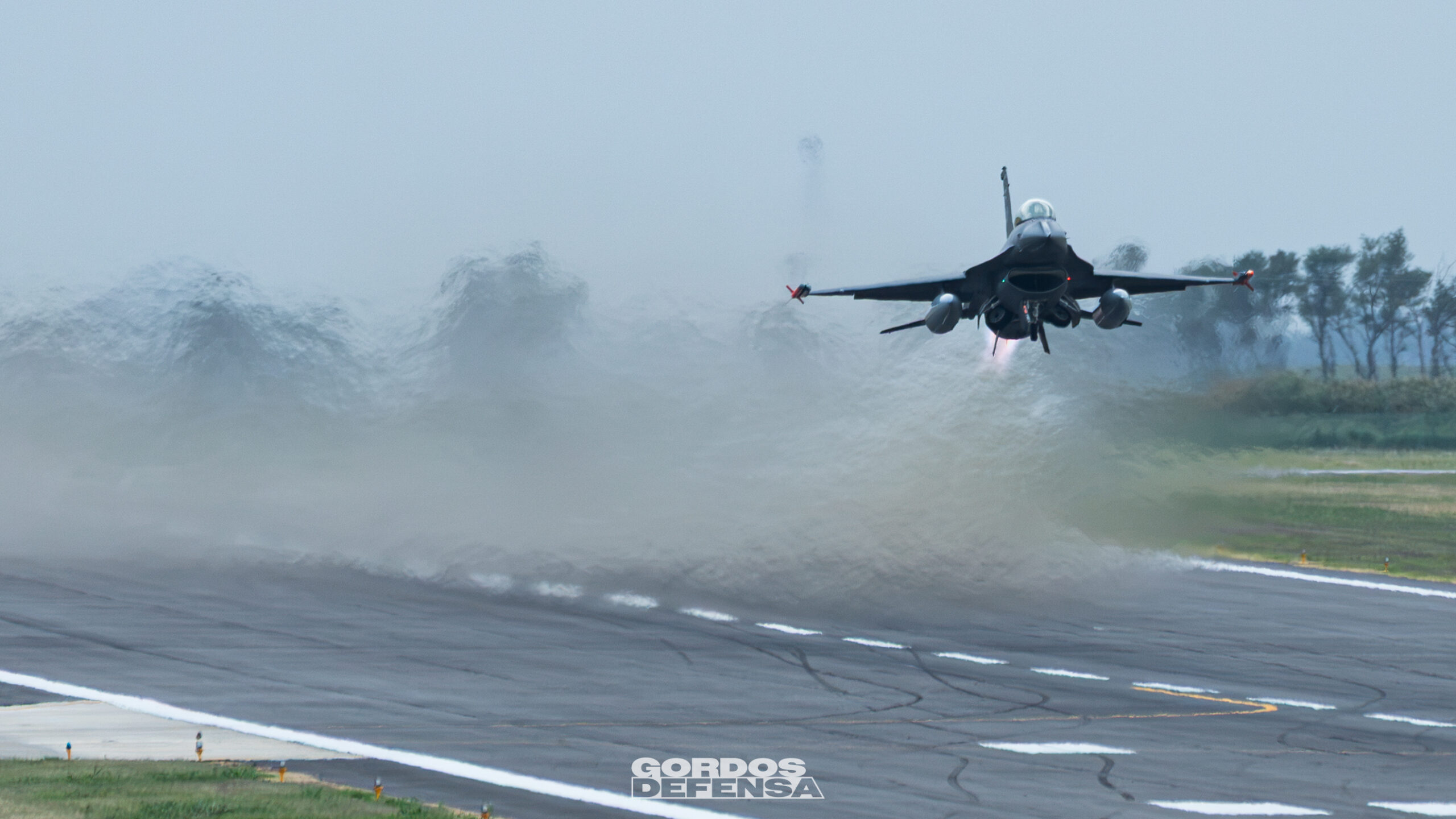 Caza F-16 de la Fuerza Aérea Argentina despegando entre la bruma de la pista