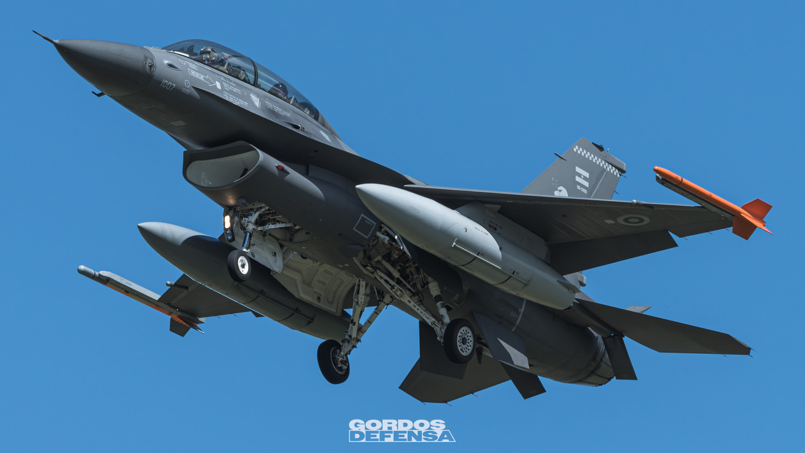Caza F-16 de la Fuerza Aérea Argentina en vuelo con tren de aterrizaje desplegado, parte de la flota alcanzada por el contrato de sostenimiento de Lockheed Martin