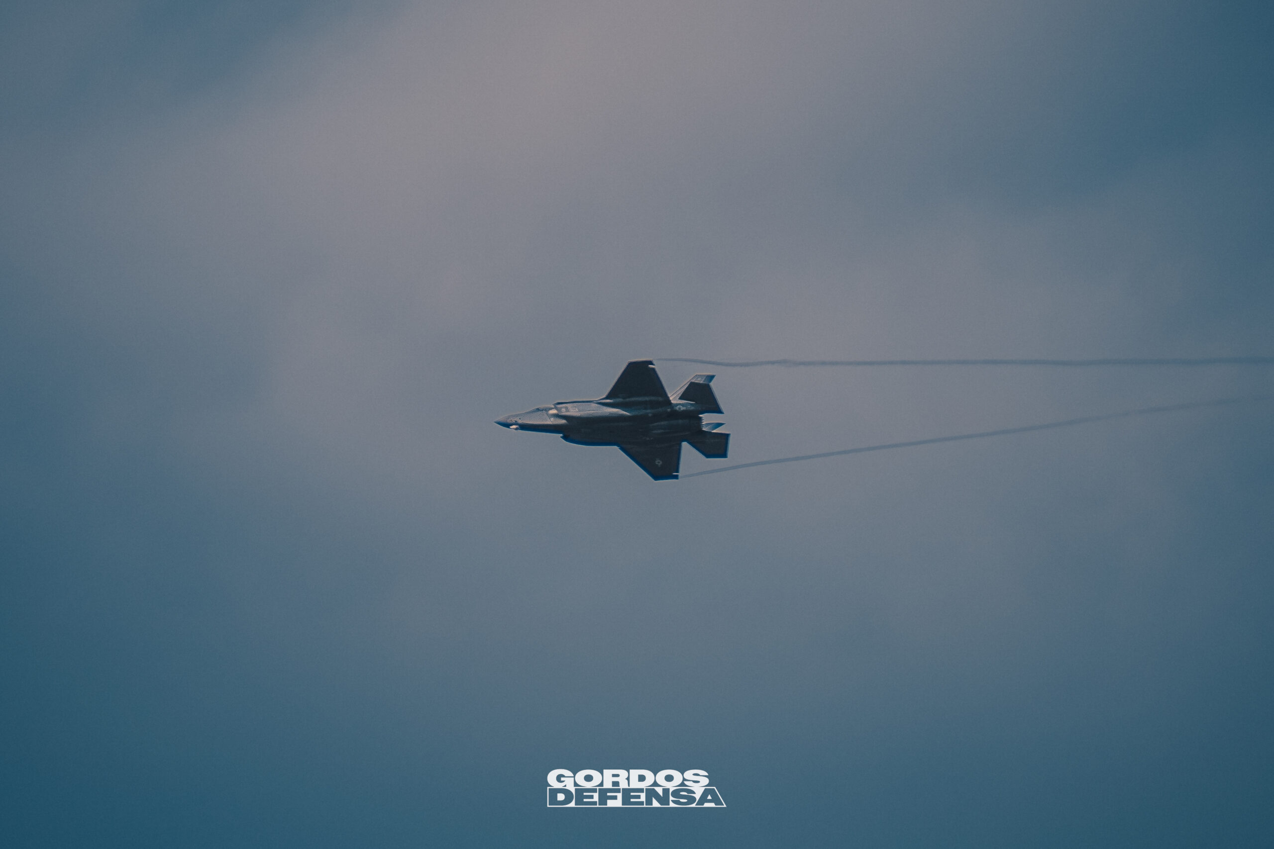 Caza F-35 Lightning II en maniobra con estelas de vapor sobre las alas