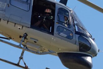 Helicóptero AS-555 Fennec de la Aviación Naval Argentina en vuelo con artillero y ametralladora en la puerta lateral