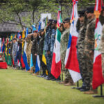 Delegaciones de fuerzas especiales formadas con sus banderas durante la ceremonia de Fuerzas Comando 2026 en Paraguay