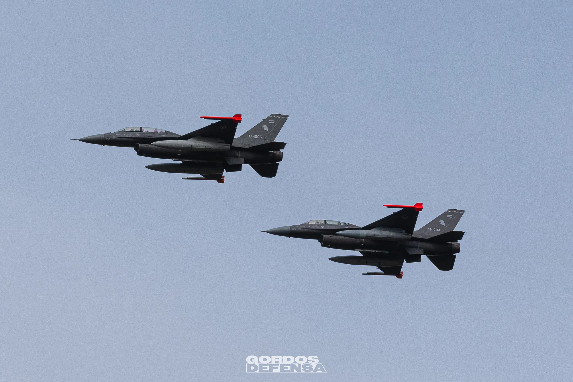 Dos cazas F-16 de la Fuerza Aérea Argentina en vuelo en formación, matrículas M-1004 y M-1005