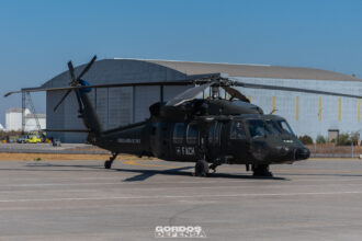Helicóptero Black Hawk matrícula H-08 de la Fuerza Aérea de Chile estacionado en plataforma frente a un hangar