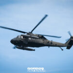 Helicóptero UH-60 Black Hawk utilitario en vuelo de perfil contra cielo azul, con tanques de combustible externos