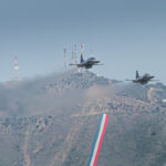 Dos cazas F-5 Tigre III de la Fuerza Aérea de Chile en vuelo bajo frente a un cerro con antenas (91)