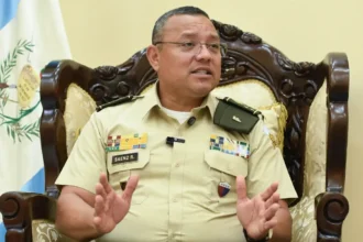 Henry David Sáenz Ramos, ministro de la Defensa Nacional de Guatemala, con uniforme militar durante una entrevista junto a la bandera guatemalteca. Foto: Prensa Libre